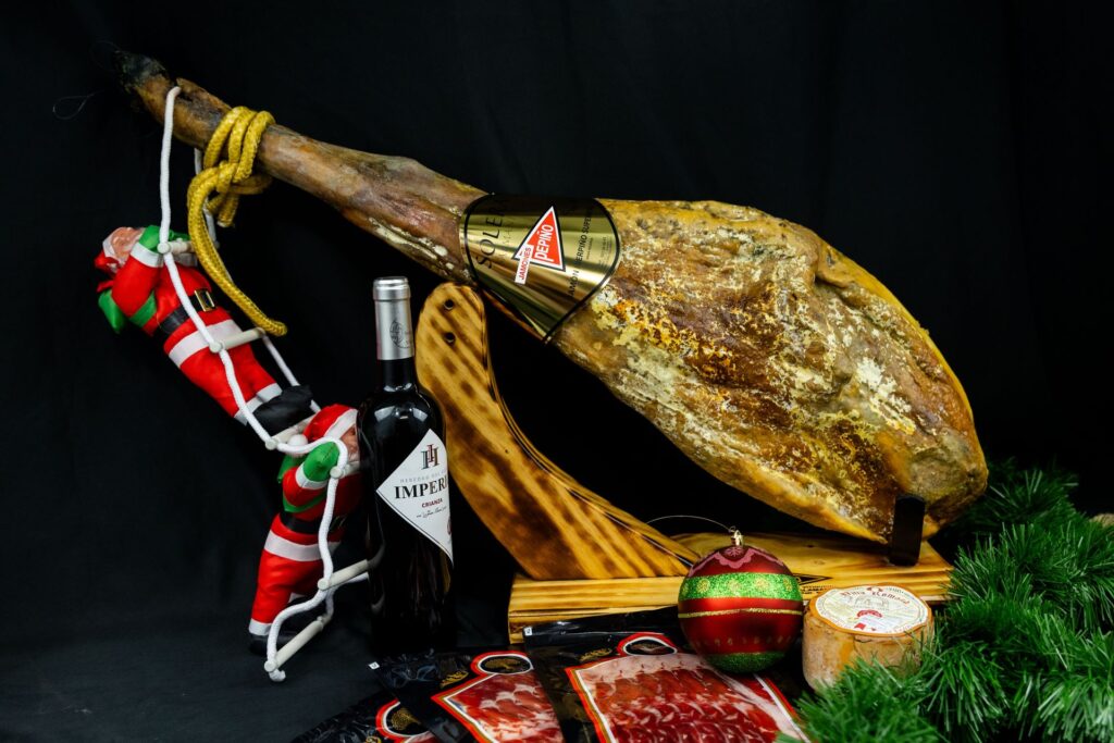 Jamón ibérico en el jamonero con vino y adornos navideños
